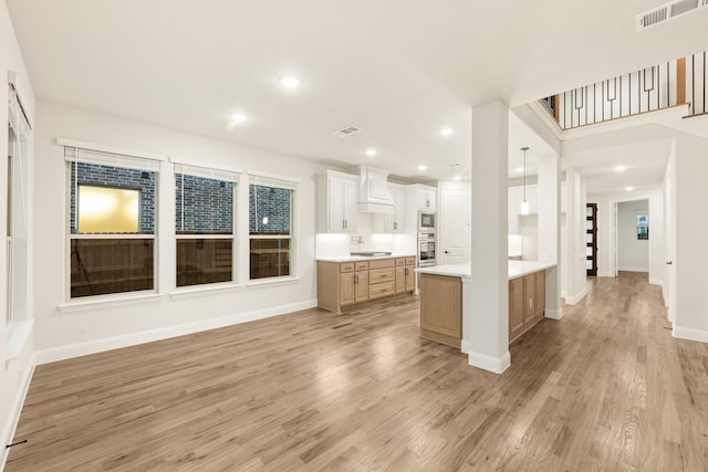 1130 Cardinal Dr, Midlothian, TX 76065 - kitchen featuring custom range hood, appliances with stainless steel finishes, light countertops, light wood finished floors, and baseboards