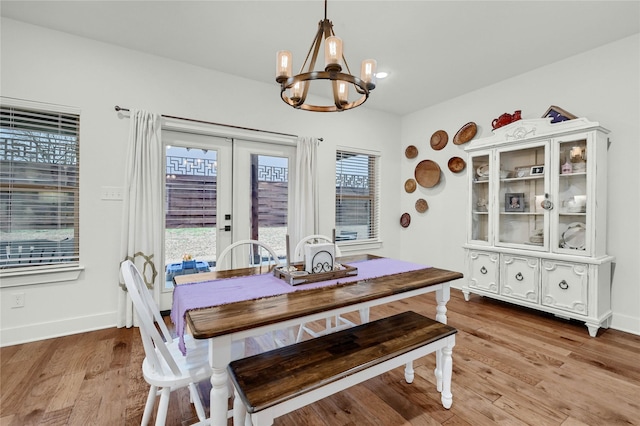 dining area featuring french doors, a chandelier, and light hardwood / wood-style flooring