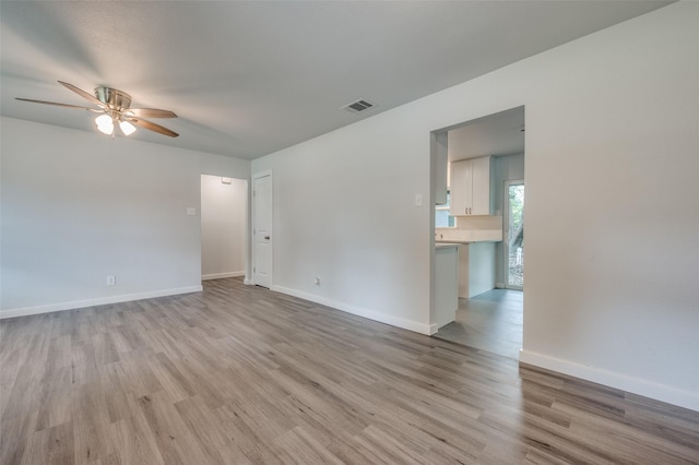 empty room with ceiling fan and light wood-type flooring