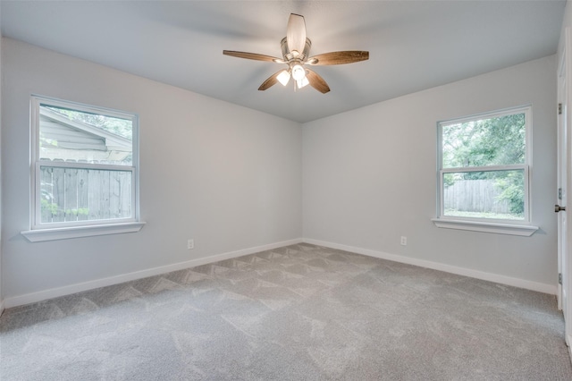 carpeted spare room featuring ceiling fan