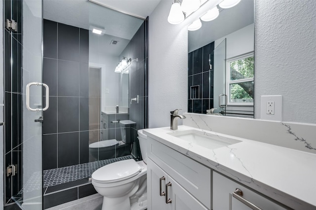 bathroom featuring vanity, an enclosed shower, and toilet