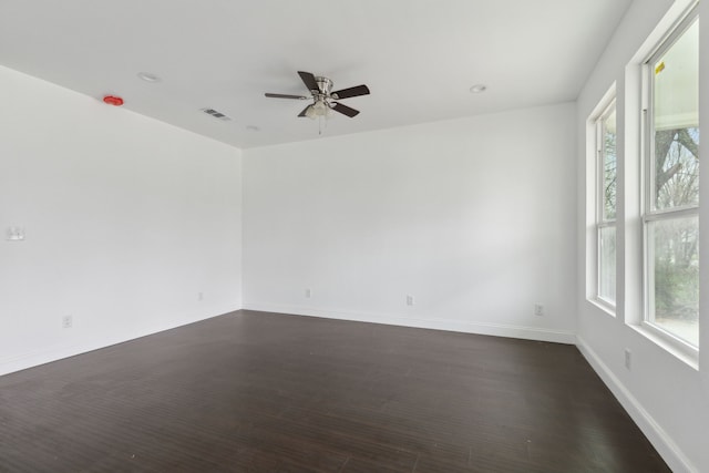 unfurnished room featuring dark wood-style flooring, recessed lighting, visible vents, a ceiling fan, and baseboards