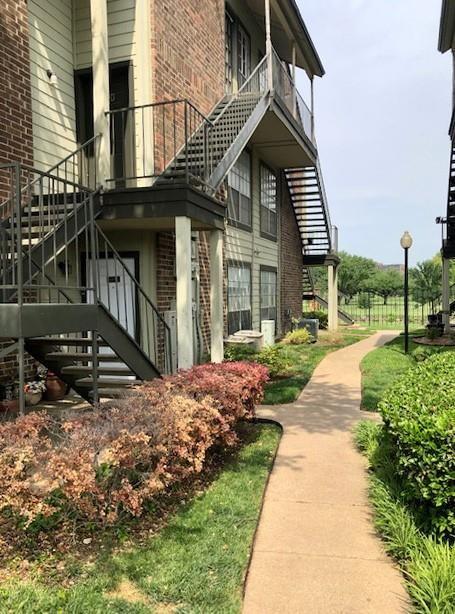 view of side of property with brick siding and stairs