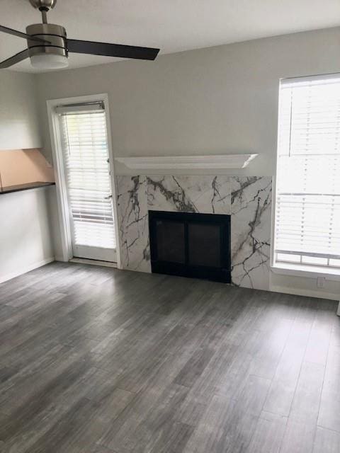 unfurnished living room featuring wood finished floors, ceiling fan, and a premium fireplace