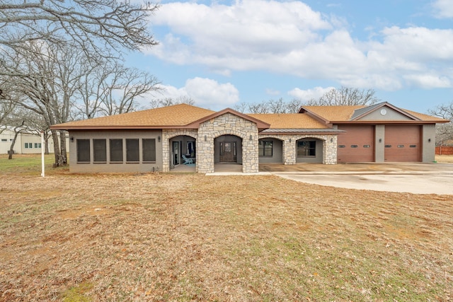 view of front of property featuring a garage and a front lawn