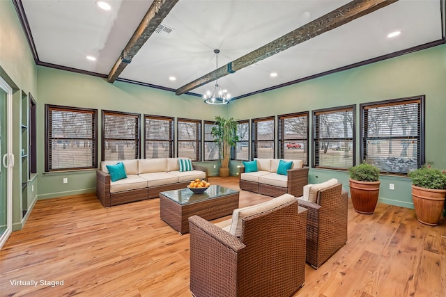 sunroom / solarium featuring an inviting chandelier and beamed ceiling