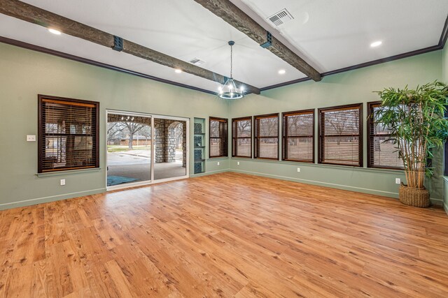 spare room featuring an inviting chandelier, light hardwood / wood-style floors, and beam ceiling