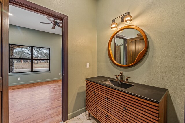 bathroom featuring hardwood / wood-style flooring, ceiling fan, and vanity