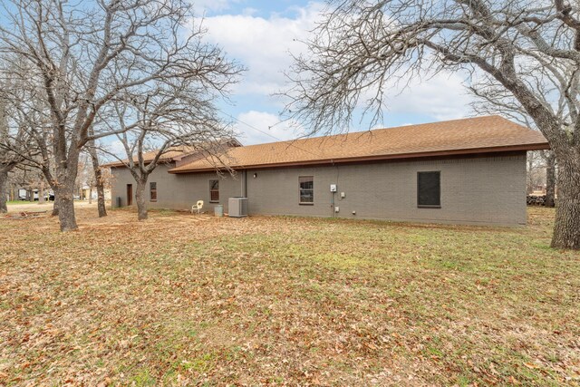 back of house featuring cooling unit and a lawn