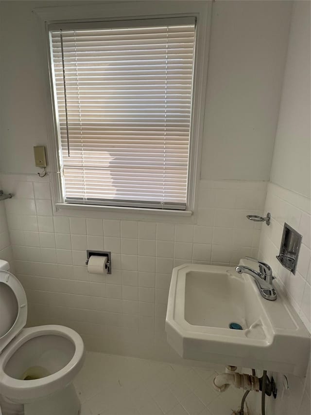 bathroom featuring tile walls, sink, and toilet