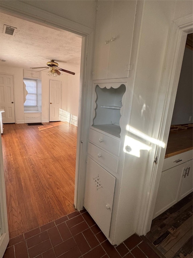 hall with dark hardwood / wood-style floors and a textured ceiling