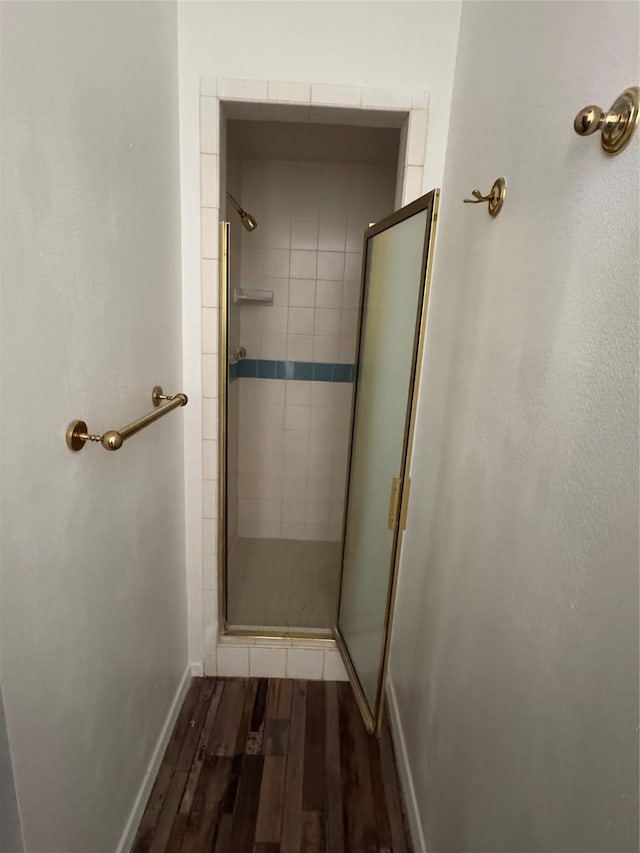 bathroom with hardwood / wood-style flooring and an enclosed shower