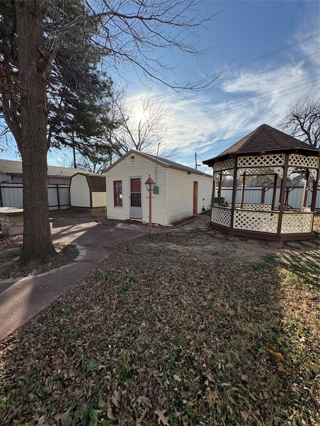 view of home's exterior with a storage shed and a gazebo