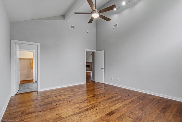 unfurnished bedroom with ceiling fan, high vaulted ceiling, ensuite bathroom, wood-type flooring, and beamed ceiling