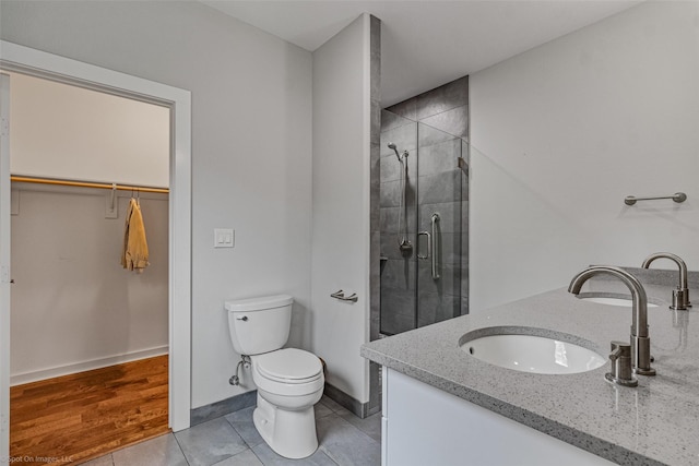 bathroom featuring walk in shower, vanity, toilet, and tile patterned flooring