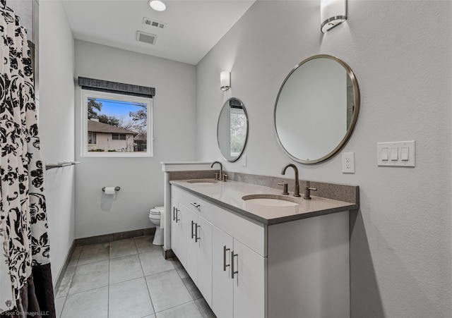 8216 Coolgreene Dr, Dallas, TX 75228 - bathroom featuring toilet, double vanity, baseboards, and tile patterned flooring