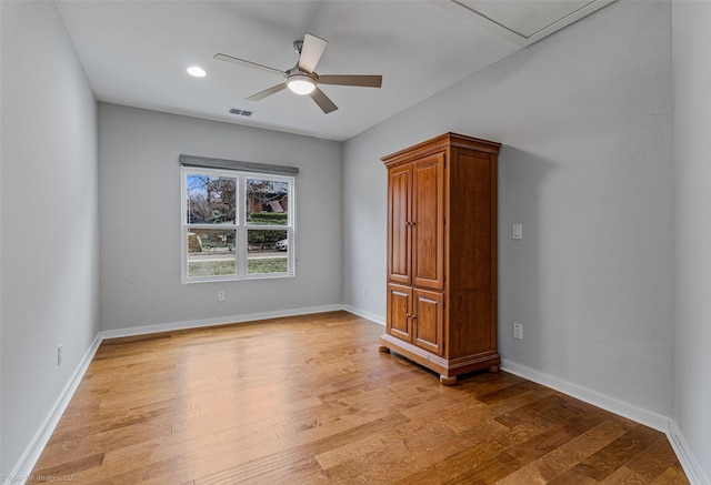 empty room with ceiling fan and light hardwood / wood-style floors