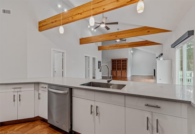 kitchen with beamed ceiling, white cabinetry, hanging light fixtures, and sink