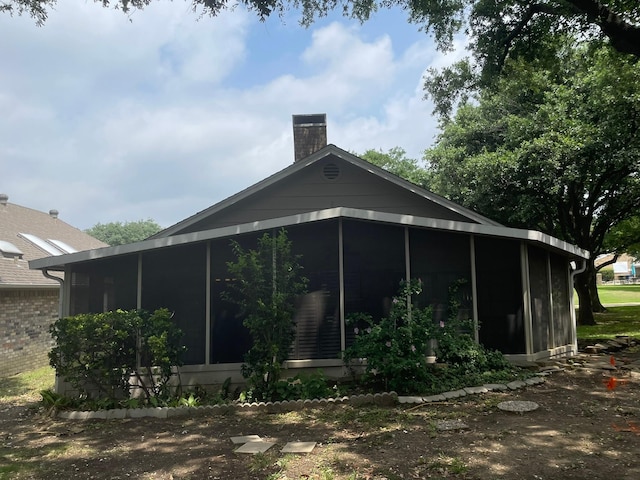 exterior space featuring a sunroom and a chimney