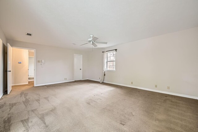 carpeted spare room featuring ceiling fan