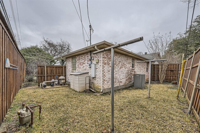 back of house with central AC and a lawn