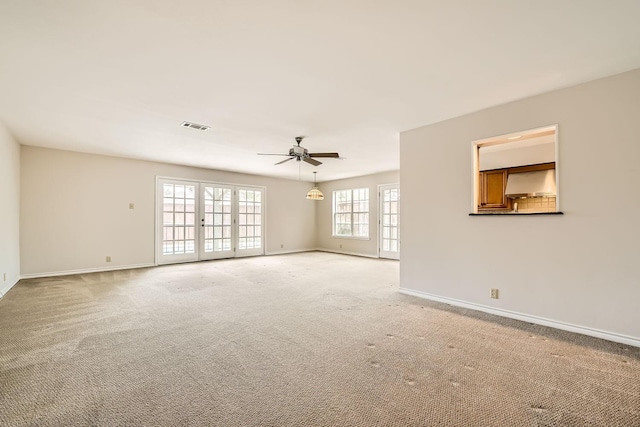 carpeted empty room with french doors and ceiling fan