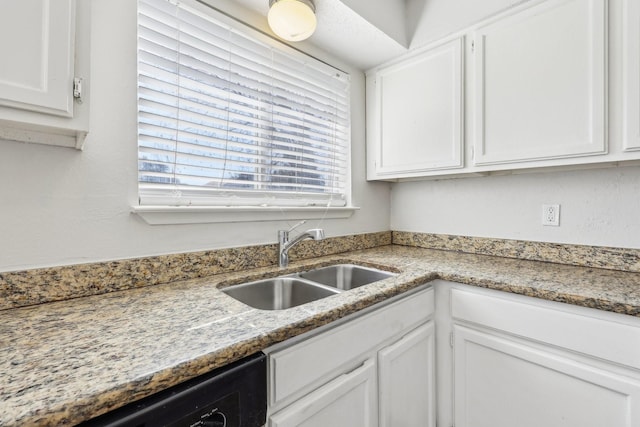 kitchen with white cabinetry, dishwasher, sink, and light stone counters