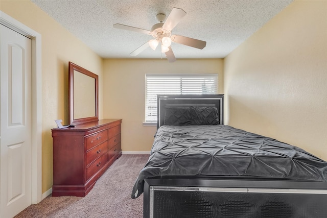 bedroom with light carpet, ceiling fan, and a textured ceiling