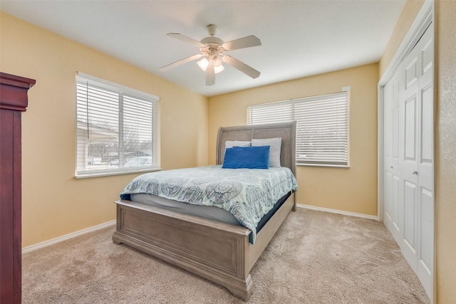 carpeted bedroom with ceiling fan and a closet