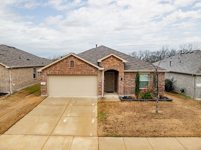 ranch-style home with driveway, roof with shingles, a garage, and brick siding