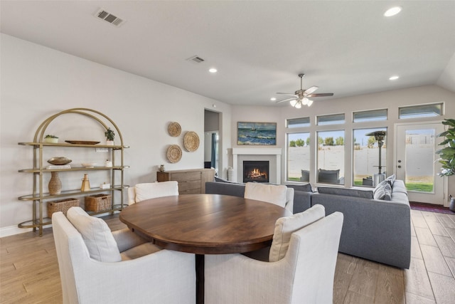 dining area featuring ceiling fan, lofted ceiling, and light hardwood / wood-style flooring