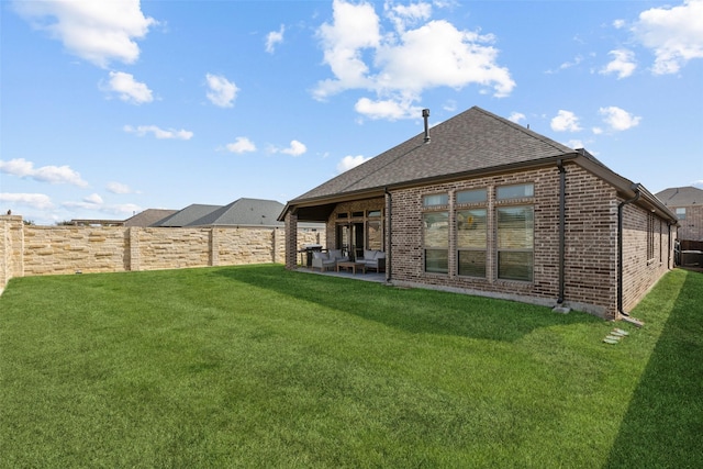 rear view of house with a yard and a patio