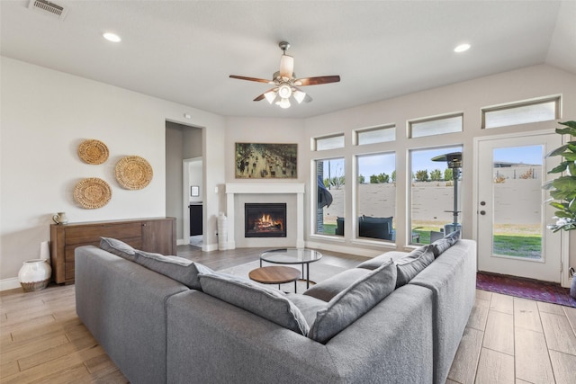 living room featuring vaulted ceiling, ceiling fan, and light hardwood / wood-style floors