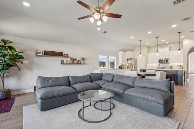 living room featuring ceiling fan and light wood-type flooring