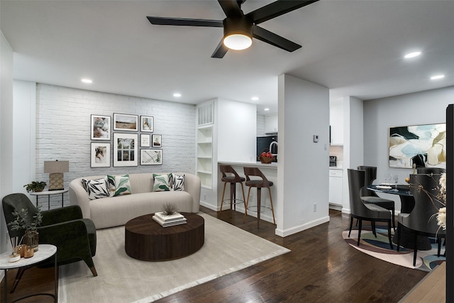 living room featuring ceiling fan and dark hardwood / wood-style flooring