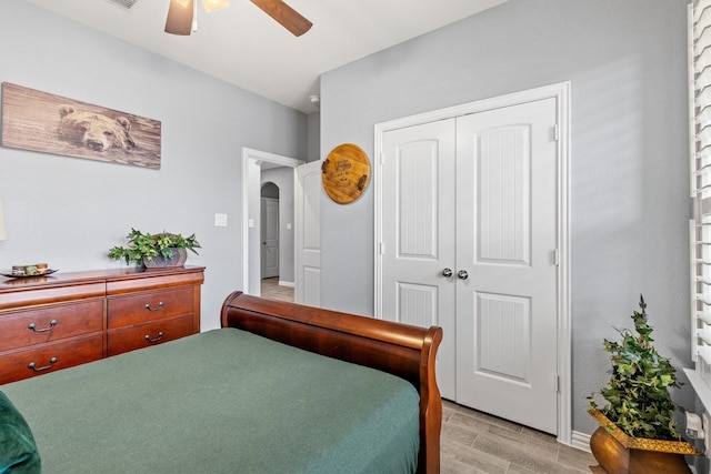 bedroom with ceiling fan, a closet, and light hardwood / wood-style flooring