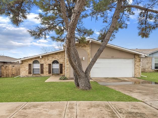 single story home with a garage and a front lawn