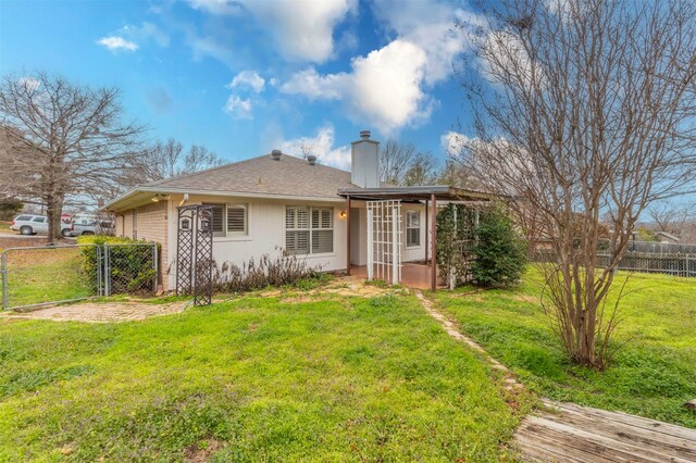 rear view of property with a lawn