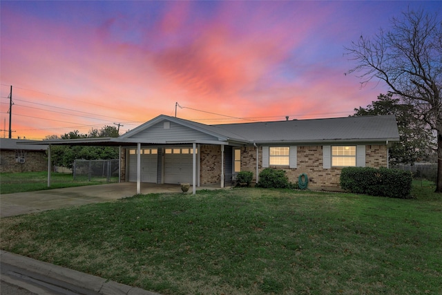 single story home featuring a yard, a garage, and a carport