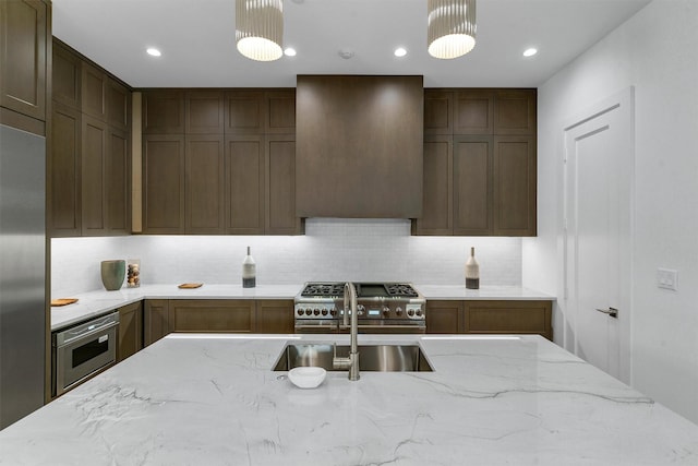 4529 Fairway, Highland Park, TX 75219 - kitchen featuring high quality appliances, a sink, decorative backsplash, light stone counters, and pendant lighting