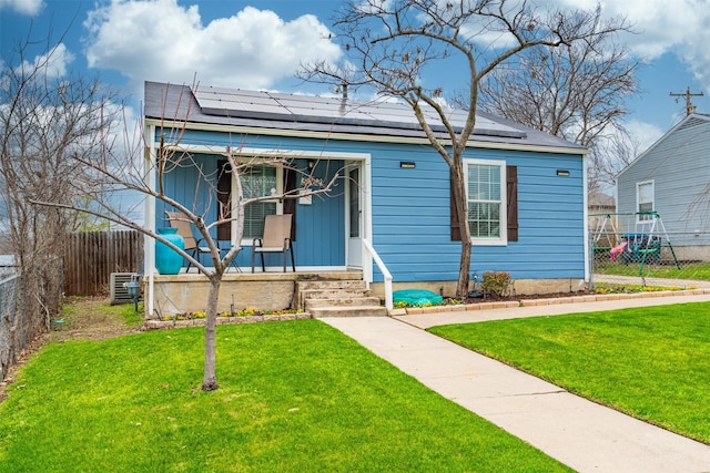 bungalow-style house featuring a porch, a front yard, and solar panels