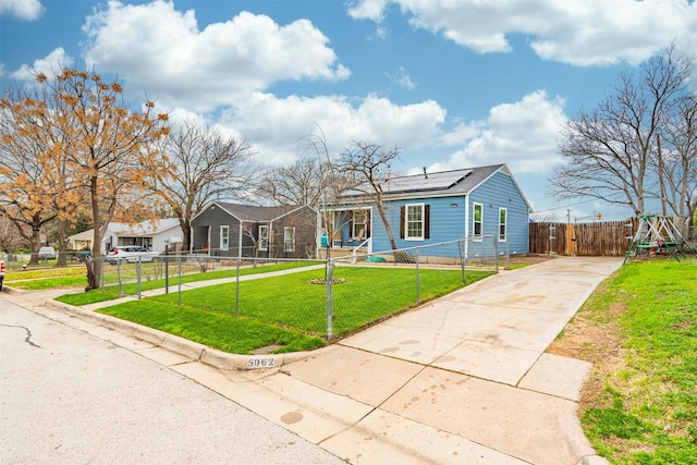 view of front of property featuring a front yard and solar panels