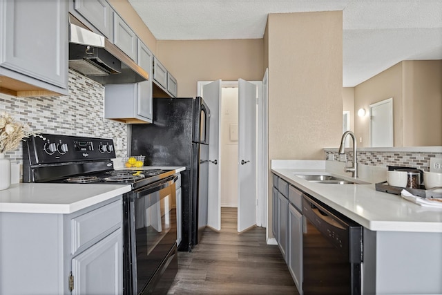 4113 Esters Rd Unit 609, Irving, TX 75038 - kitchen with light countertops, a sink, dark wood-style floors, under cabinet range hood, and black appliances