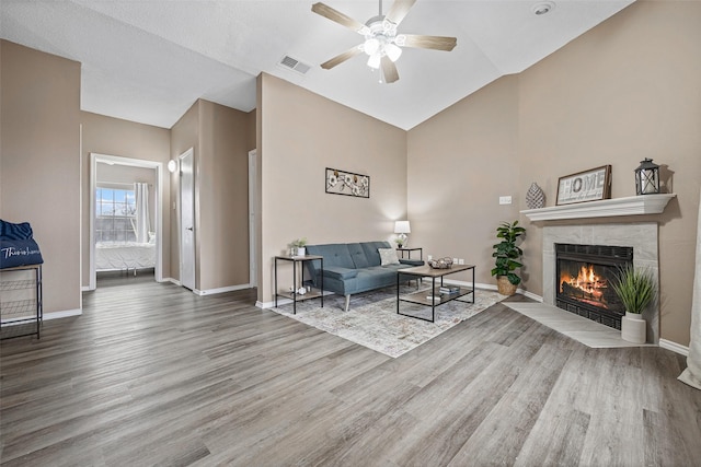4113 Esters Rd Unit 609, Irving, TX 75038 - living area featuring a tile fireplace, baseboards, wood finished floors, a ceiling fan, and vaulted ceiling