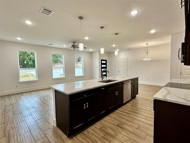 kitchen featuring pendant lighting, an island with sink, dishwasher, and sink