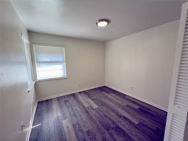 empty room with dark hardwood / wood-style flooring