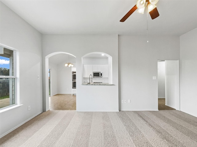 spare room featuring ceiling fan, sink, and light colored carpet