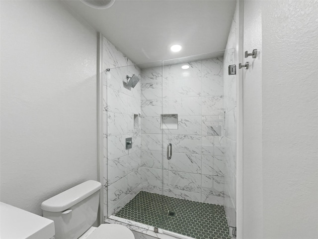 bathroom with a shower with door and toilet