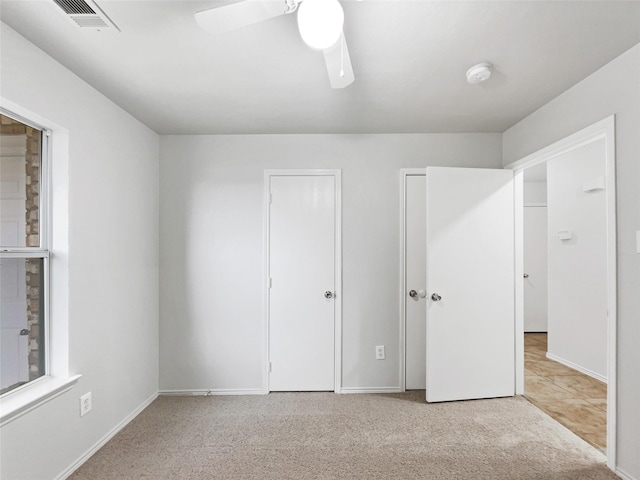 unfurnished bedroom featuring ceiling fan and light colored carpet