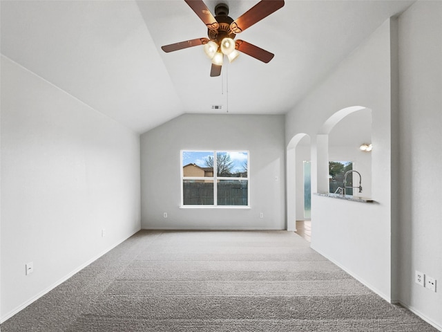 interior space featuring vaulted ceiling, light carpet, and ceiling fan